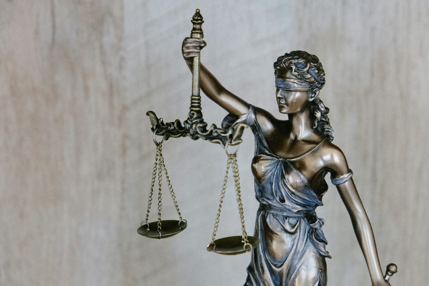 Bronze statue of Lady Justice holding scales, representing legal and estate structure work