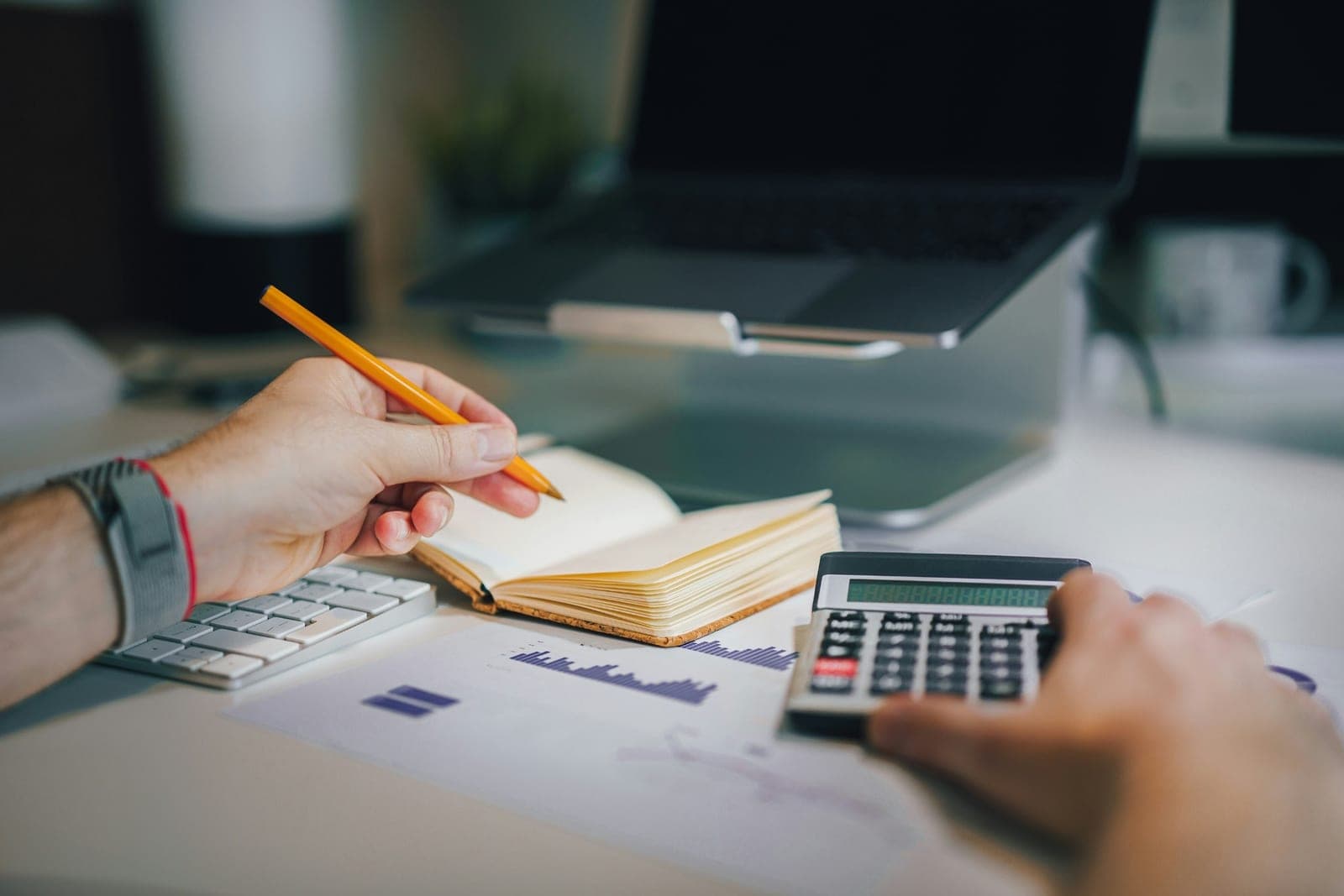 Advisor and client reviewing financial charts together with a notepad and calculator
